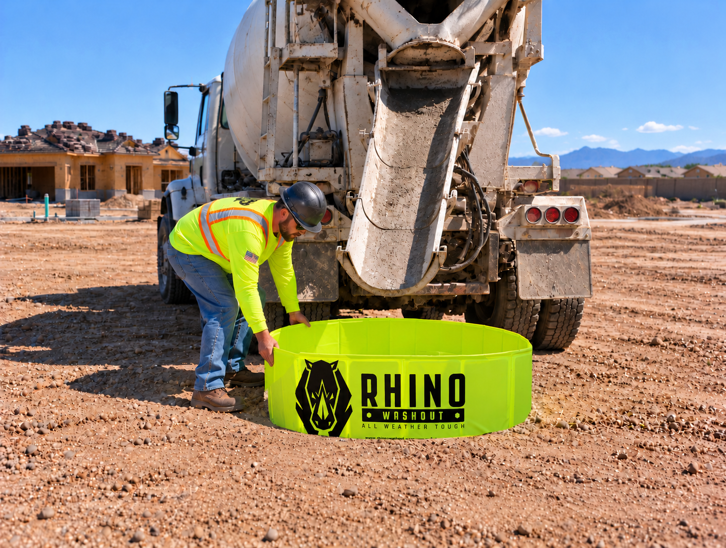Worker placing Rhino Washout behind a concrete mixer truck