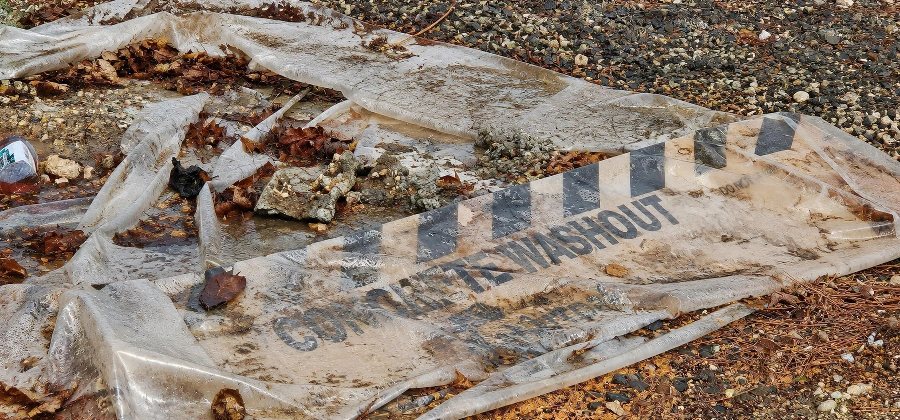 Collapsed concrete washout sheet on gravel
